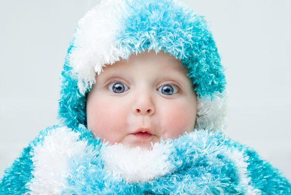 کودک ناز در پس زمینه زمستان