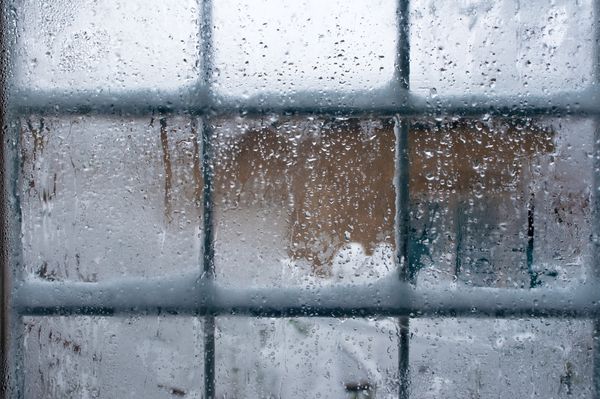 پنجره زمستانی قطرات آب و دانه های برف روی شیشه پنجره