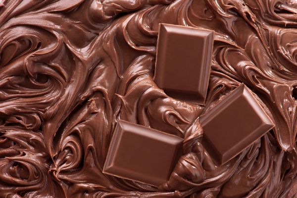 نمای نزدیک از شکلات ذوب شده و تکه های شکلات