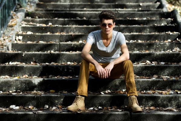 پرتره یک مرد جوان خوش تیپ مدل مد با تیوپی در پله ها