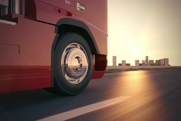 کامیون حمل و نقل بزرگ هنگام غروب آفتاب به سرعت در جاده حرکت می کند