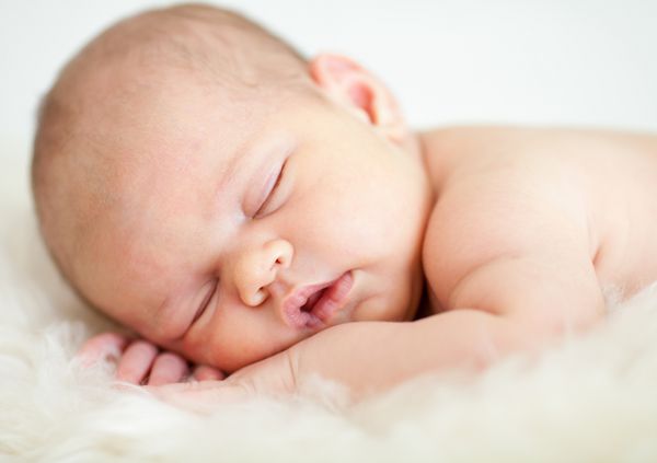 کودک دوست داشتنی که روی شکم می خوابد