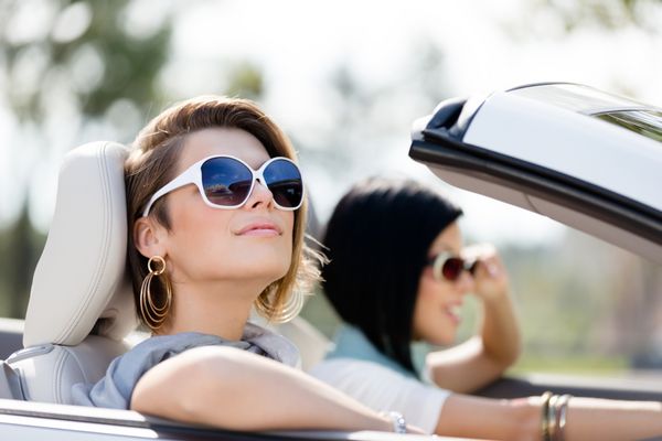 از نزدیک دخترانی که در ماشین سفید عینک آفتابی دارند سفر کوچک تعطیلات دوستان