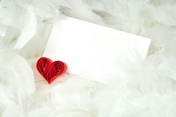قلب روبان قرمز با کاغذ در پس زمینه کرکی سفید