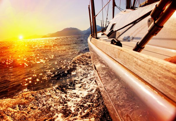 قایق بادبانی در برابر غروب آفتاب قایق بادبانی قایق سواری کشتیرانی مفهوم سفر تعطیلات