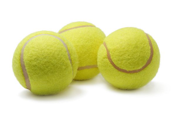 چند توپ تنیس جدا شده در پس زمینه سفید
