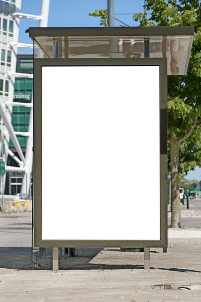 تصویری از یک ایستگاه اتوبوس با تابلوی خالی برای تبلیغات شما که در مقابل آسمان خراش چرخشی نیم تنه در شهر مالمو سوئد قرار دارد