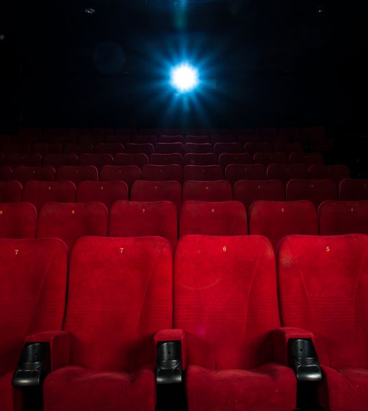 صندلی های قرمز راحت خالی با اعداد در سینما