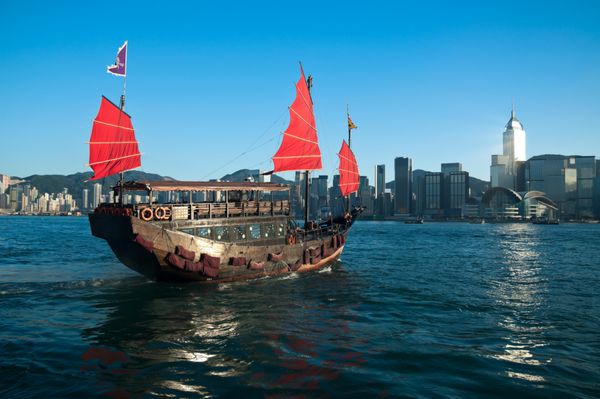 یک کشتی آشغال سنتی در سراسر بندر ویکتوریا در هنگ کنگ حرکت می کند
