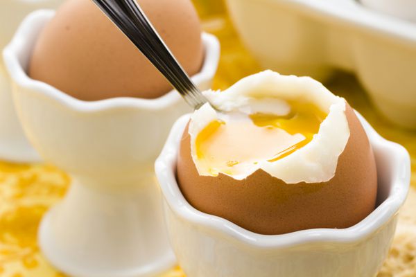 تخم مرغ آب پز نرم در فنجان تخم مرغ و با نان تست سرو می شود