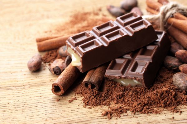 ترکیب شیرینی شکلاتی کاکائو و ادویه جات بر روی پس زمینه چوبی