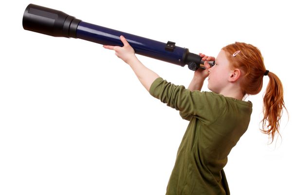 دختر جوان از طریق تلسکوپ در پس زمینه سفید نگاه می کند