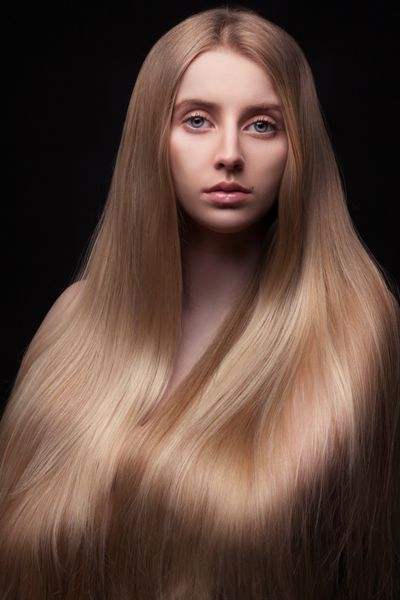پو زن جوان زیبا با موهای باشکوه در پس زمینه مشکی