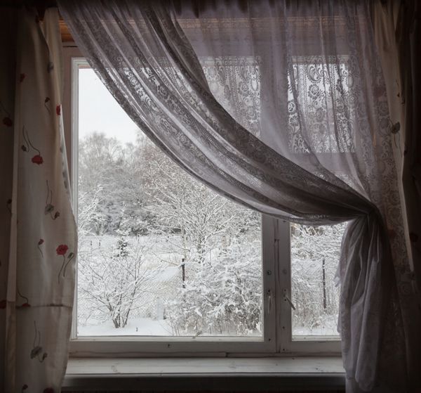 نمایی از پنجره خانه روستایی در زمستان منطقه مسکو روسیه