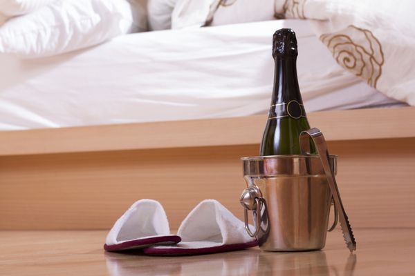شامپاین با سطل و کفش نزدیک به تخت
