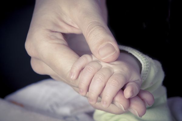 دست نوزادی که انگشت مادر را گرفته است