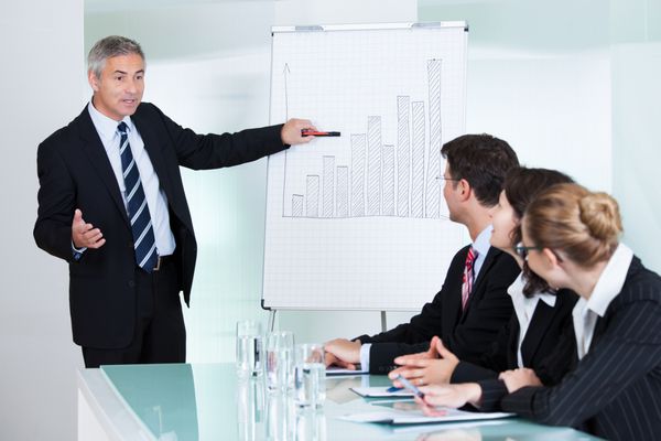 یک مدیر ارشد تجاری که در طی یک جلسه یا آموزش کسب و کار داخلی به همکاران خود ارائه می دهد