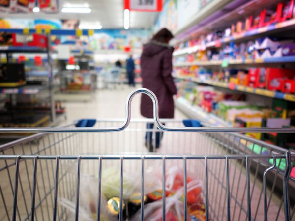 زن با چرخ دستی در سوپرمارکت خرید می کند