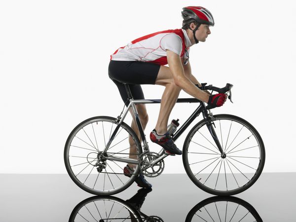 نمای جانبی دوچرخه سواری که روی دوچرخه در پس زمینه سفید نصب شده است