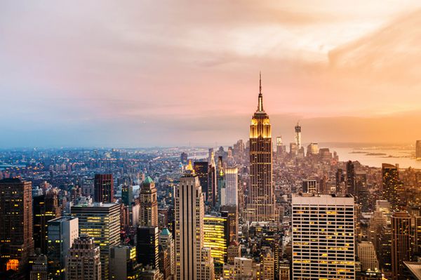 خط افق شهر نیویورک با آسمان خراش های شهری در غروب آفتاب