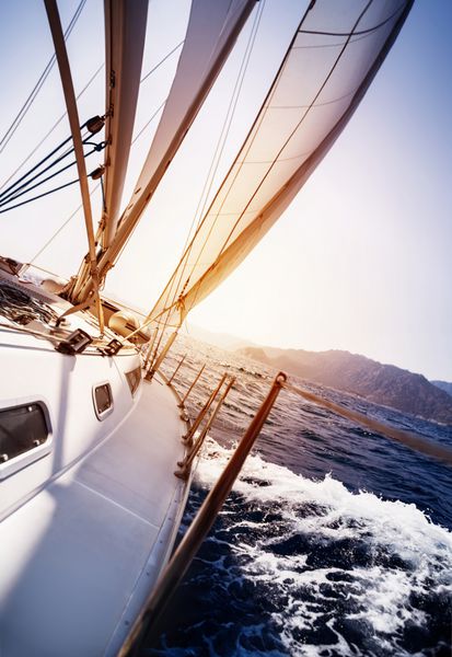 قایق تفریحی لوکس در حال عمل در دریا در پس زمینه غروب خورشید ورزش قایقرانی حمل و نقل آبی سفر دریایی تابستانی مسافرت و مفهوم گردشگری