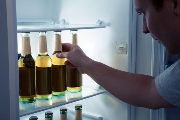 مردی که بطری را از یخچال انتخاب می کند