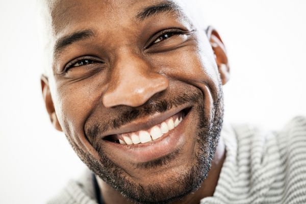 پرتره نزدیک از یک مرد سیاهپوست شاد 20 ساله که روی پس زمینه سفید جدا شده است