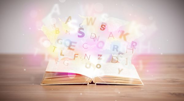 کتاب باز با حروف درخشان در زمینه بتونی مفهوم آموزش رنگارنگ