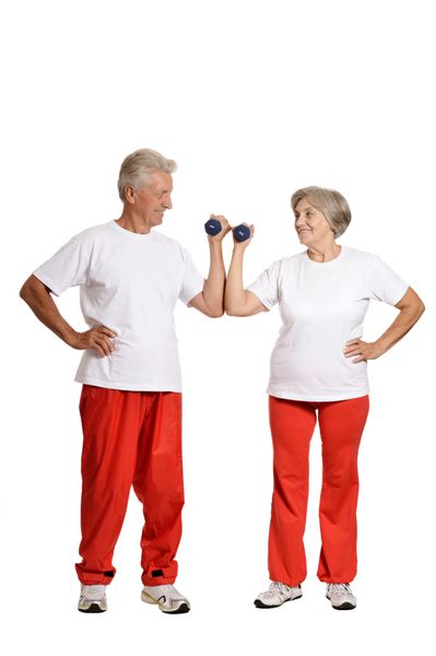 پرتره یک زوج سالمند در حال ورزش با دمبل در پس زمینه سفید
