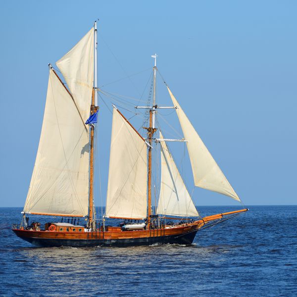 کشتی بلند تاریخی قدیمی قایق بادبانی با بادبان های سفید در دریای آبی