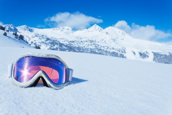 ماسک اسکی و اسنوبرد در برف با کپی sp و کوه در پس زمینه