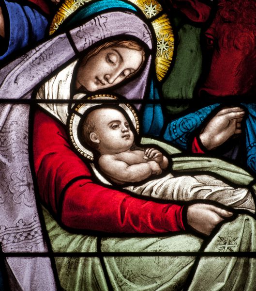 جزئیات پنجره شیشه ای رنگی که صحنه کریسمس عیسی نوزاد با مریم را به تصویر می کشد