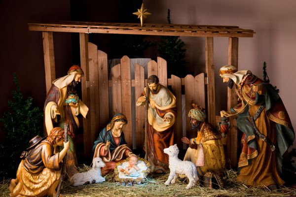 صحنه آخور کریسمس با مجسمه هایی از جمله عیسی مریم یوسف گوسفند و مغ