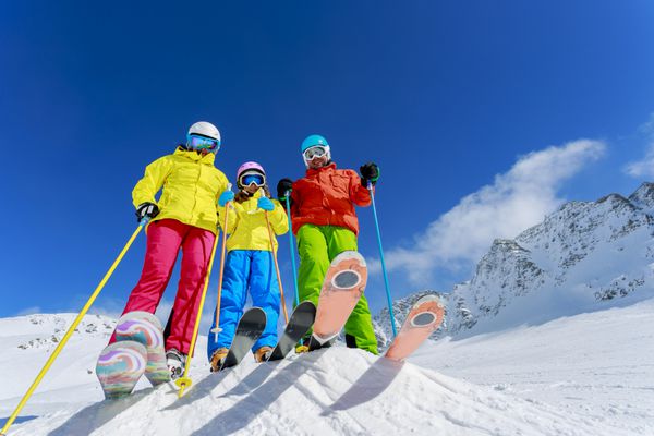 اسکی زمستان برف اسکی بازان آفتاب و سرگرمی - خانواده در حال لذت بردن از تعطیلات زمستانی