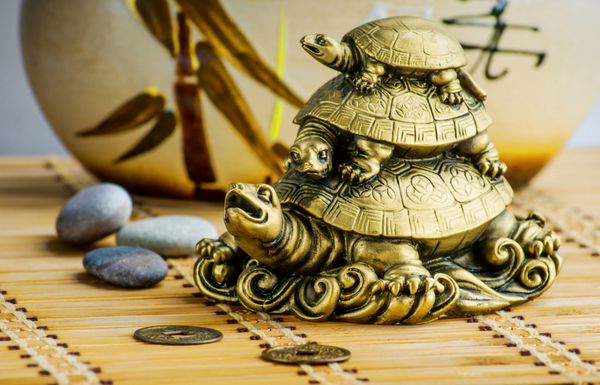مجسمه طلایی لاک پشت های فنگ شویی روی یک تشک بامبو