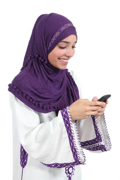 زن زیبای عرب در حال مرور تلفن هوشمند خود جدا شده بر روی پس زمینه سفید