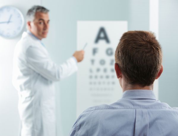 اپتومتریست و بیمار پزشک با اشاره به نمودار چشم