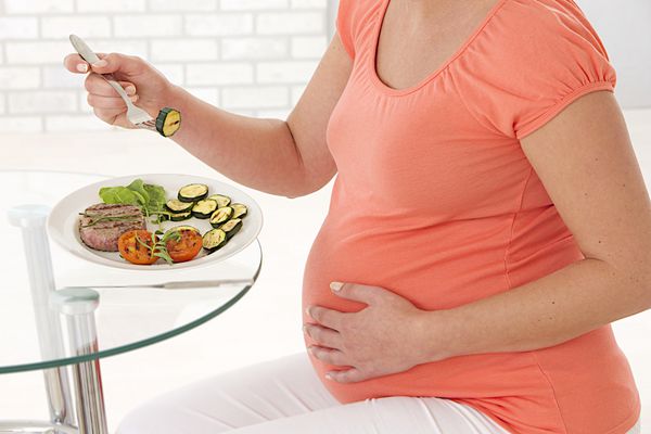زن باردار در حال خوردن غذای سالم