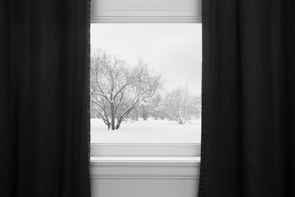 منظره زمستانی از پنجره با پرده های سیاه دیده می شود