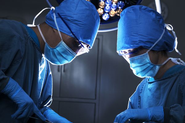 دو جراح در حال کار و تمرکز روی میز عمل