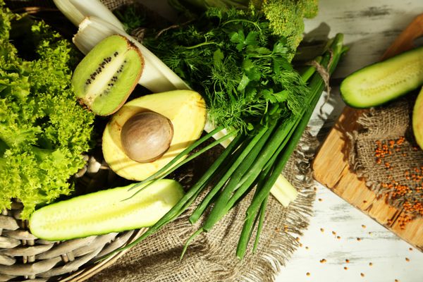 سبزیجات و میوه های سبز تازه در زمینه چوبی