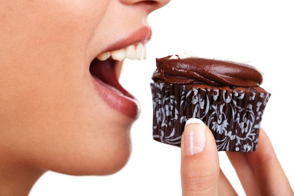 نمای نزدیک از زن در حال خوردن کیک شکلاتی