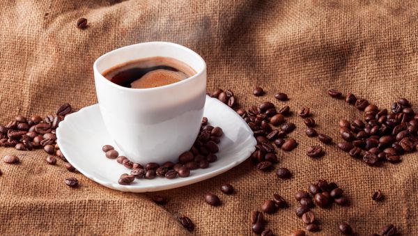طبیعت بی جان افقی با فنجان قهوه و دانه های قهوه
