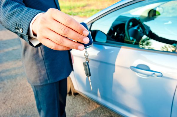 مرد-مدیر کلید را به خریدار خودروی جدید منتقل می کند