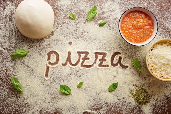 کلمه پیتزا نوشته شده روی ترکیب میز با مواد تشکیل دهنده