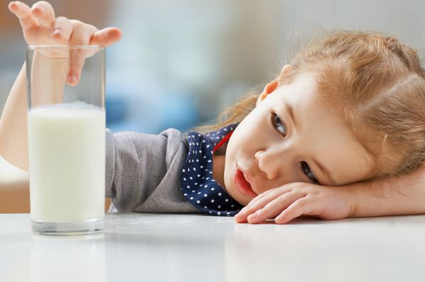 دختری که در آشپزخانه شیر می خورد