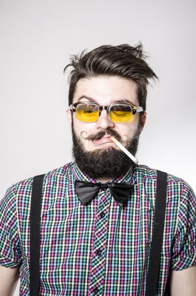 مردی با ریش پر با عینک و سیگار کشیدن