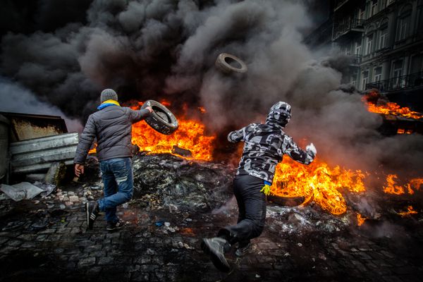 انقلابیون برای دفاع در برابر حمله پلیس لاستیک ها را در آتش می اندازند اوکراین کیف در 23 ژانویه 2014