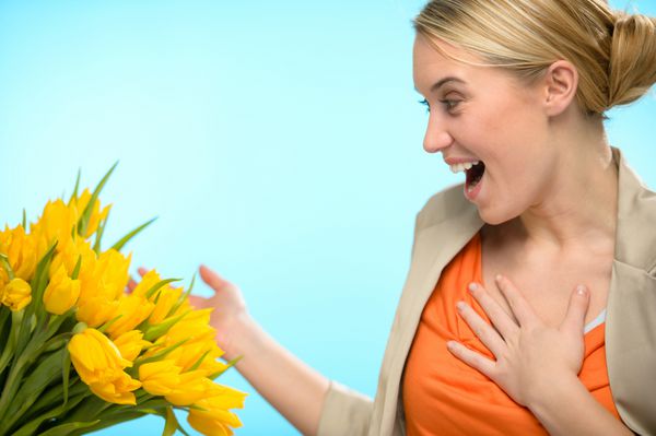زن متعجب دسته گل لاله زرد بهار دریافت می کند