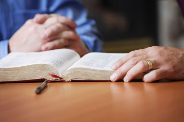 کتاب مقدس و دست های دعا کننده